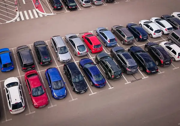 A car lot with 20+ cars in parking spots.